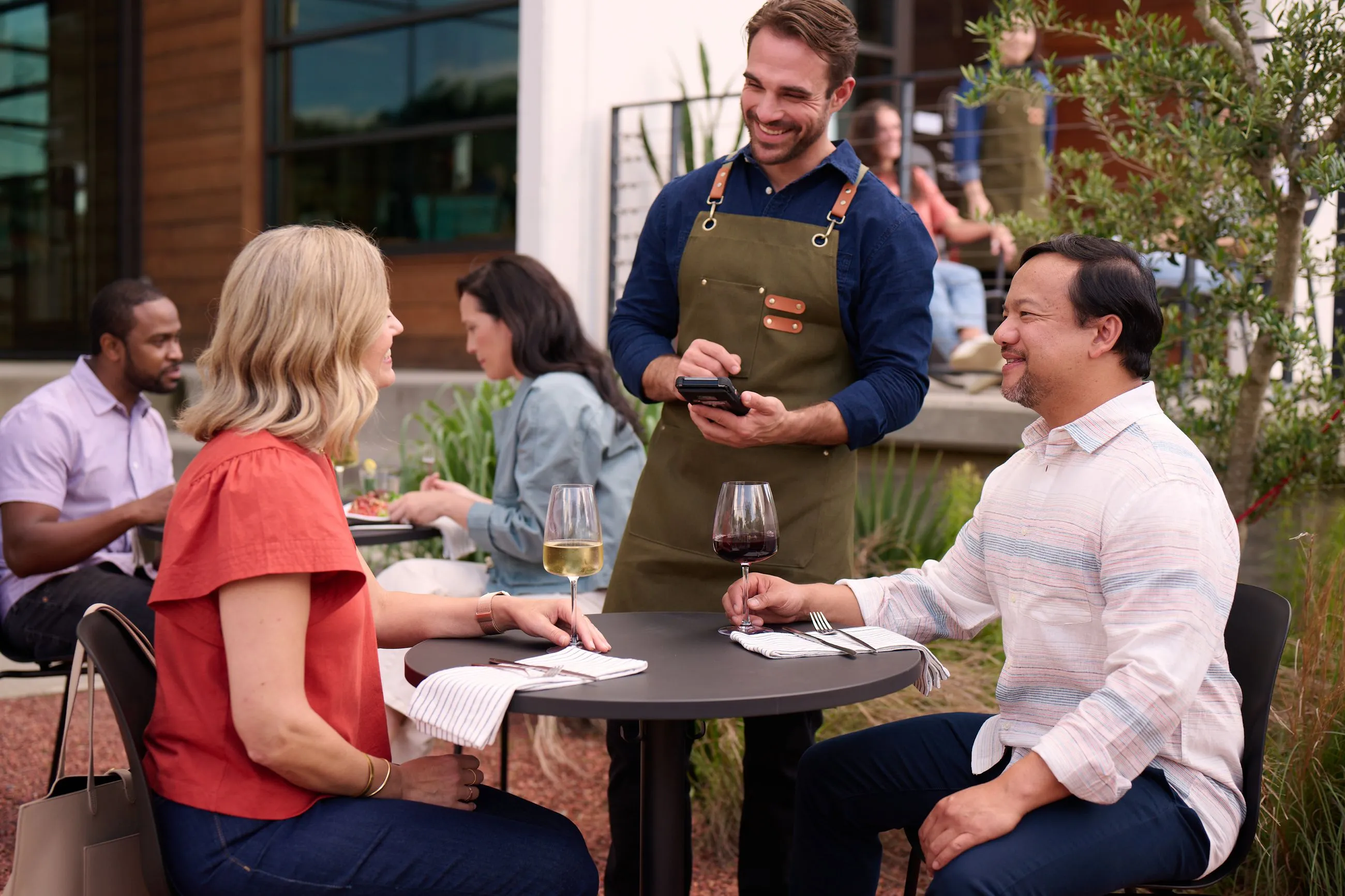 Server using NCR Voyix OrderPay to take an order at the table